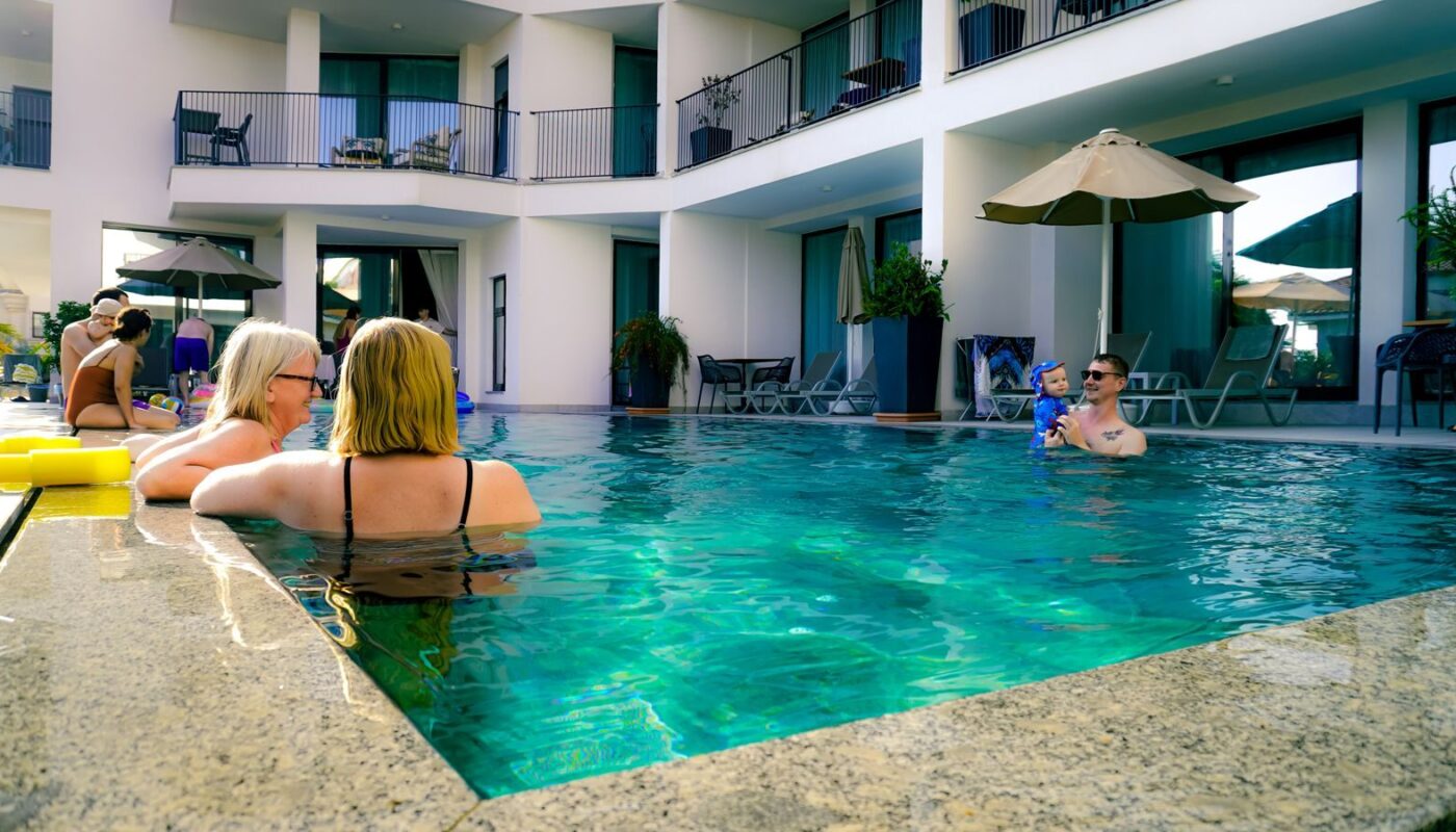 Guests enjoying a relaxing summer day at a hotel's outdoor swimming pool.