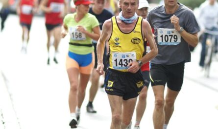 A diverse group of athletes participates in an outdoor marathon race, demonstrating energy and fitness.