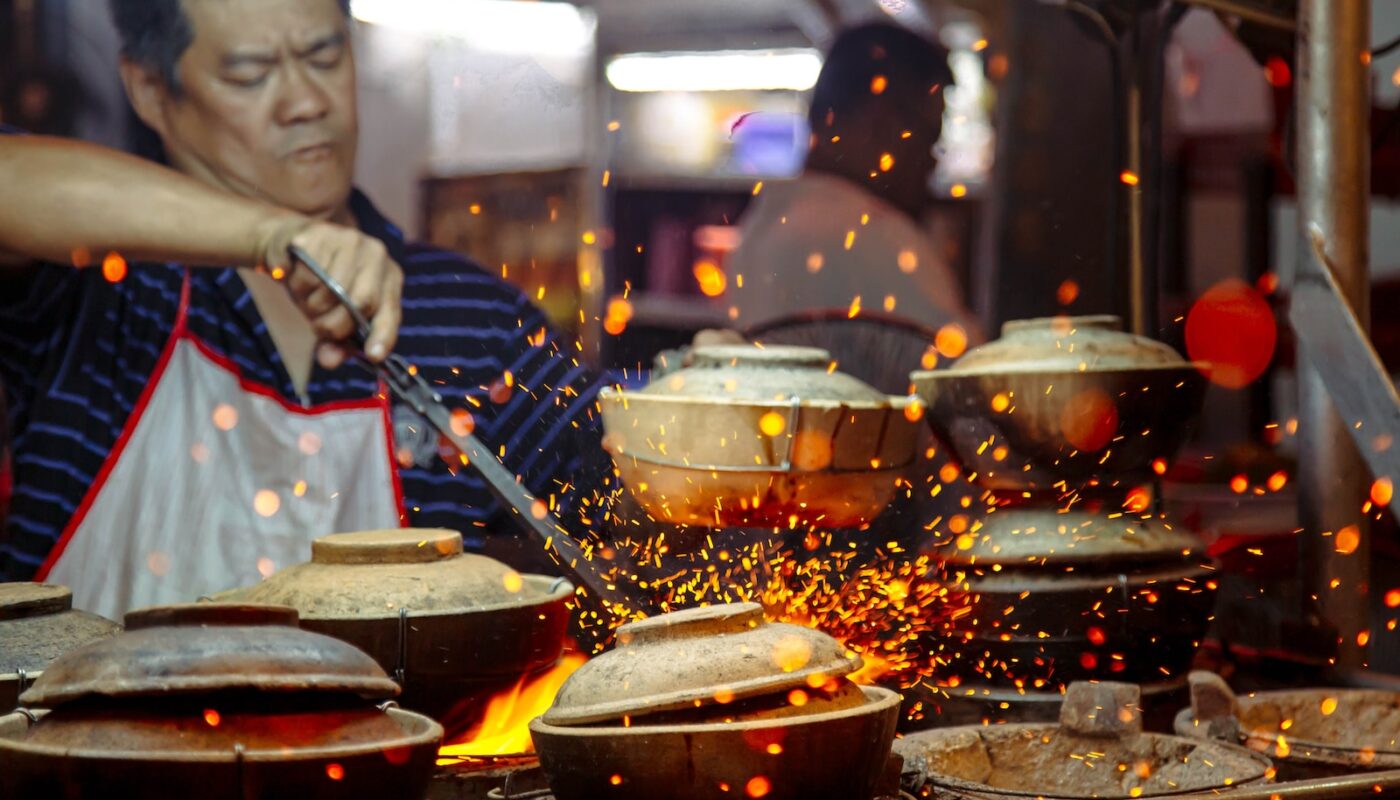 man holding tongs while cooking
