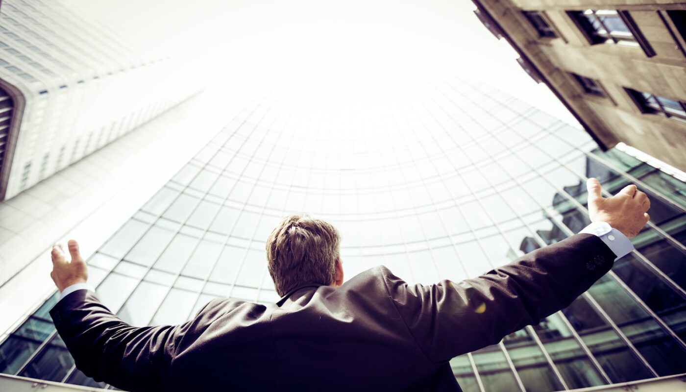 low-angle photography of man in the middle of buidligns